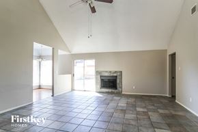 Houston house for rent - an empty living room with a fireplace and a ceiling fan