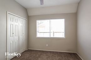 Houston house for rent - a bedroom with a large window and carpeted flooring