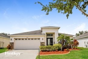 Riverview house for rent - a white house with a garage door and a lawn