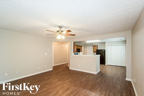 Lawrenceville house for rent - A spacious room with a ceiling fan and wooden flooring.