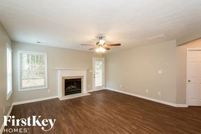 Lawrenceville house for rent - A room with a fireplace and a ceiling fan.
