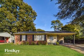 Memphis house for rent - a small brick house with a green lawn and trees