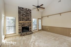 Lewisville house for rent - A living room with a fireplace and a fan.