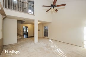 Lewisville house for rent - A spacious living room with a fan and a staircase.