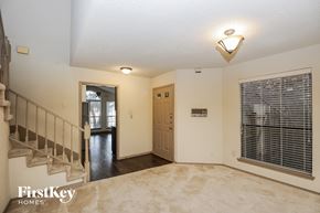 Lewisville house for rent - A spacious room with a staircase and a door leading to another room.