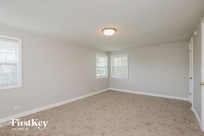 Winthrop Harbor house for rent - a bedroom with a carpeted floor and two windows