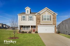 Kernersville house for rent - A house with a garage and a tree in front of it.