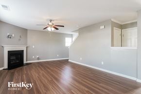 Kernersville house for rent - A spacious living room with a fireplace and wood flooring.
