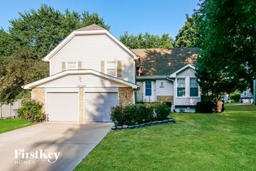 Olathe house for rent - a white house with a white garage door and a green lawn