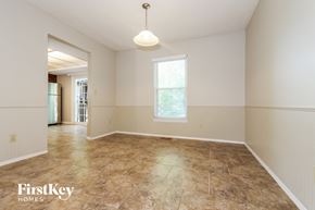 Olathe house for rent - an empty living room with tile flooring and a window