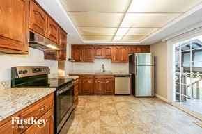 Olathe house for rent - a kitchen with wooden cabinets and stainless steel appliances