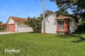 Port St. Lucie house for rent - a small white house with a red door and a grassy yard