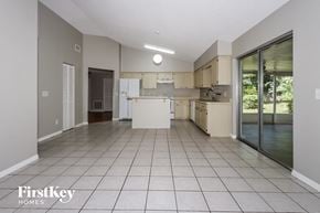 Port St. Lucie house for rent - a large kitchen with white cabinets and a sliding glass door