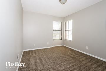 Port St. Lucie house for rent - a spacious living room with carpet and two windows