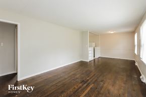 Gladstone house for rent - A room with wooden floors and white walls.