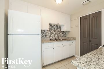 Phoenix house for rent - A kitchen with a white fridge and a granite counter top.