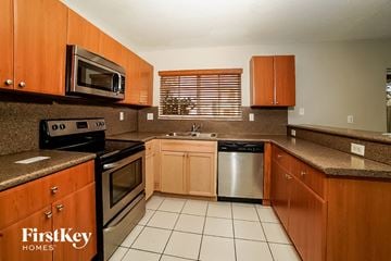 Homestead house for rent - A kitchen with wooden cabinets and a stainless steel dishwasher.