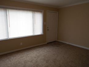 Florissant house for rent - A room with a carpeted floor, a window with blinds, and a closed door.
