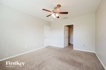 Cape Coral house for rent - a spacious living room with carpet and a ceiling fan