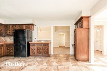 Blue Springs house for rent - A kitchen with a black fridge and wooden cabinets.