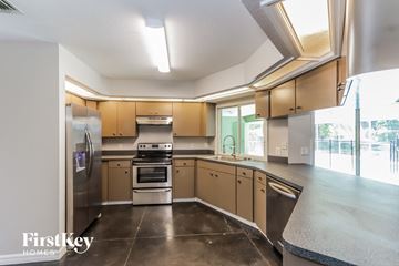Lakeland house for rent - a kitchen with stainless steel appliances and wooden cabinets