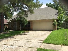 Houston house for rent - a house with a driveway and a garage door