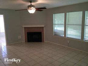 Houston house for rent - a living room with a fireplace and a ceiling fan
