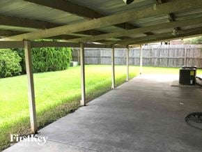 Houston house for rent - a covered patio with grass and a trash can