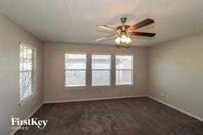 Houston house for rent - a living room with a ceiling fan and three windows