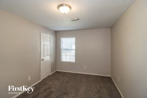 Houston house for rent - a bedroom with a carpeted floor and a white door and window