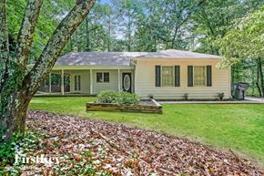 Conyers house for rent - A house with a porch and a tree in front of it.