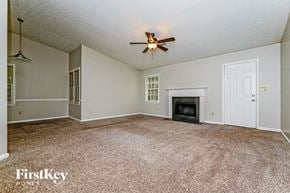 Conyers house for rent - A spacious living room with a fireplace and a ceiling fan.