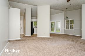 Conyers house for rent - A sparsely furnished room with a carpeted floor and a hanging light fixture.