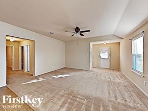 Royse City house for rent - A spacious room with a carpeted floor and a ceiling fan.