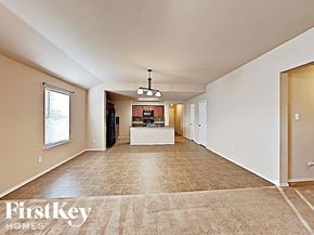 Royse City house for rent - A spacious living room with a kitchen in the background.