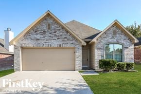 Dallas house for rent - a house with a garage door and a lawn