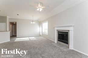 Dallas house for rent - an empty living room with a fireplace and a ceiling fan