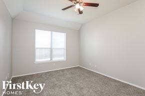 Dallas house for rent - a bedroom with a ceiling fan and a window