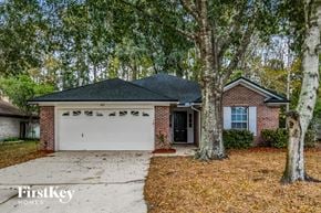 Fleming Island house for rent - A house with a garage and a tree in front of it.