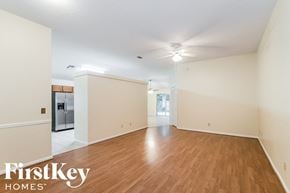 Fleming Island house for rent - A spacious room with wooden floors and a refrigerator in the corner.