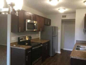 Garland house for rent - a kitchen with black cabinets and stainless steel appliances