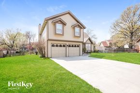 Olathe house for rent - a beige house with a garage and a driveway