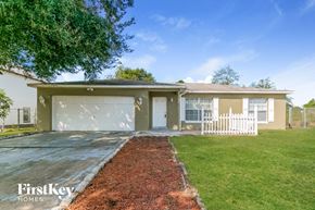 Poinciana house for rent - a house with a lawn and a white fence