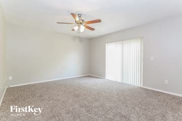 Poinciana house for rent - a spacious living room with carpet and a ceiling fan