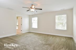 Mcleansville house for rent - a bedroom with a ceiling fan and a carpeted floor