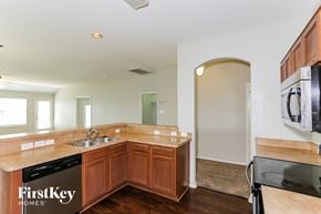 Lancaster house for rent - a kitchen with wooden cabinets and a sink and counter top