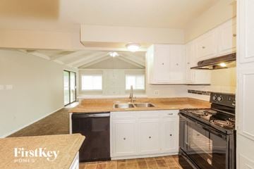 Independence house for rent - A kitchen with white cabinets and a black stove top oven.