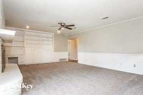 Hurst house for rent - A spacious room with a ceiling fan and a door leading to another room.