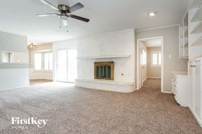 Hurst house for rent - A spacious living room with a fireplace and a ceiling fan.