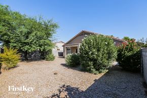 Surprise house for rent - a house with a gravel driveway with trees and bushes